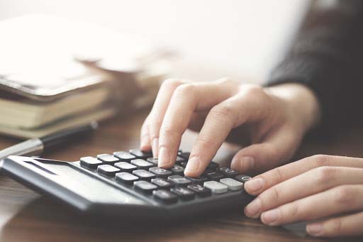 Hand using calculator on the table