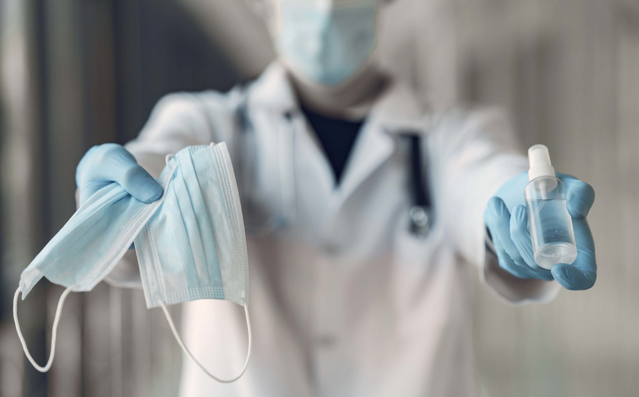 Doctor hold the antiseptic and masks in his hand