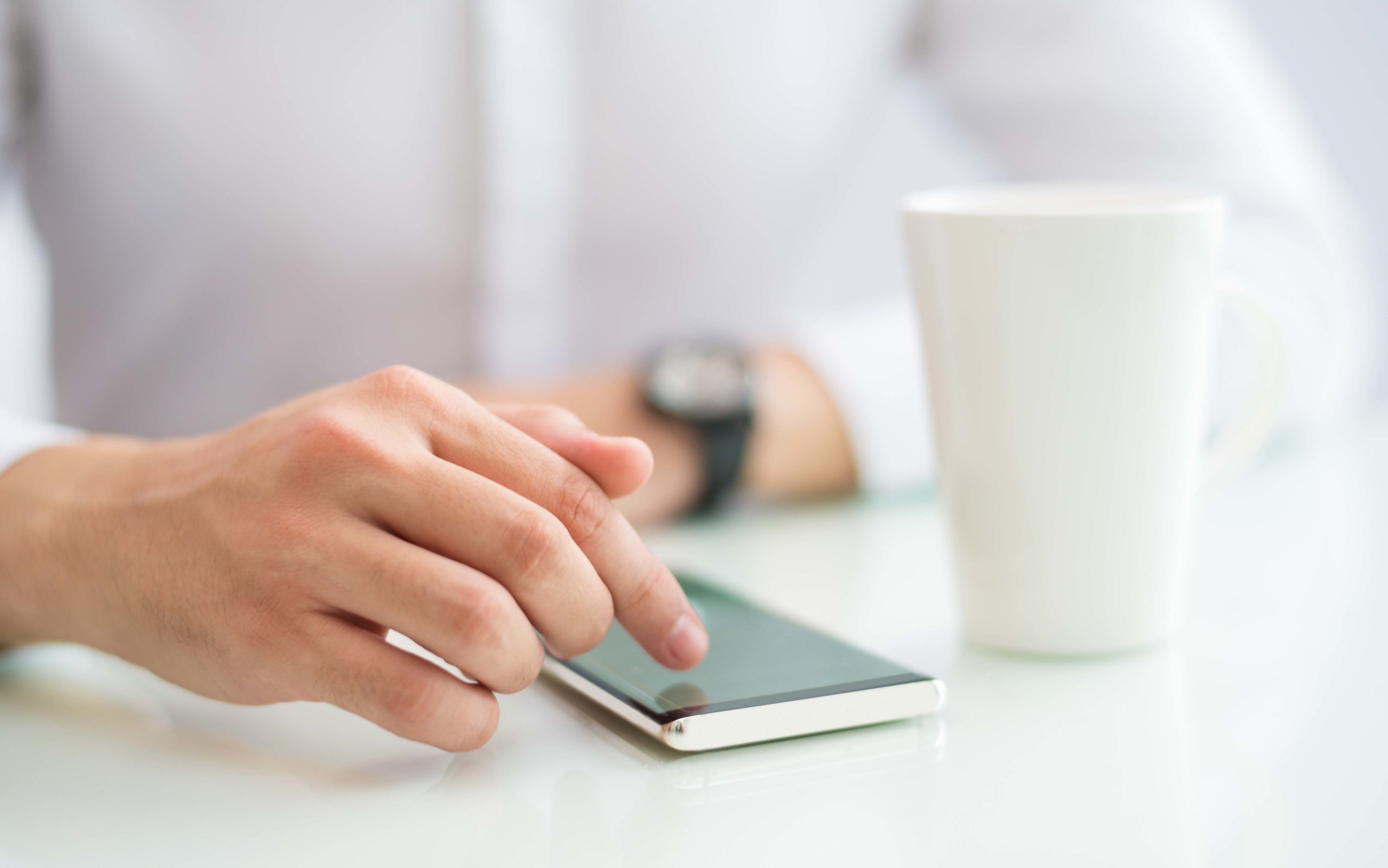 Close-up of businessman touching screen of smartphone
