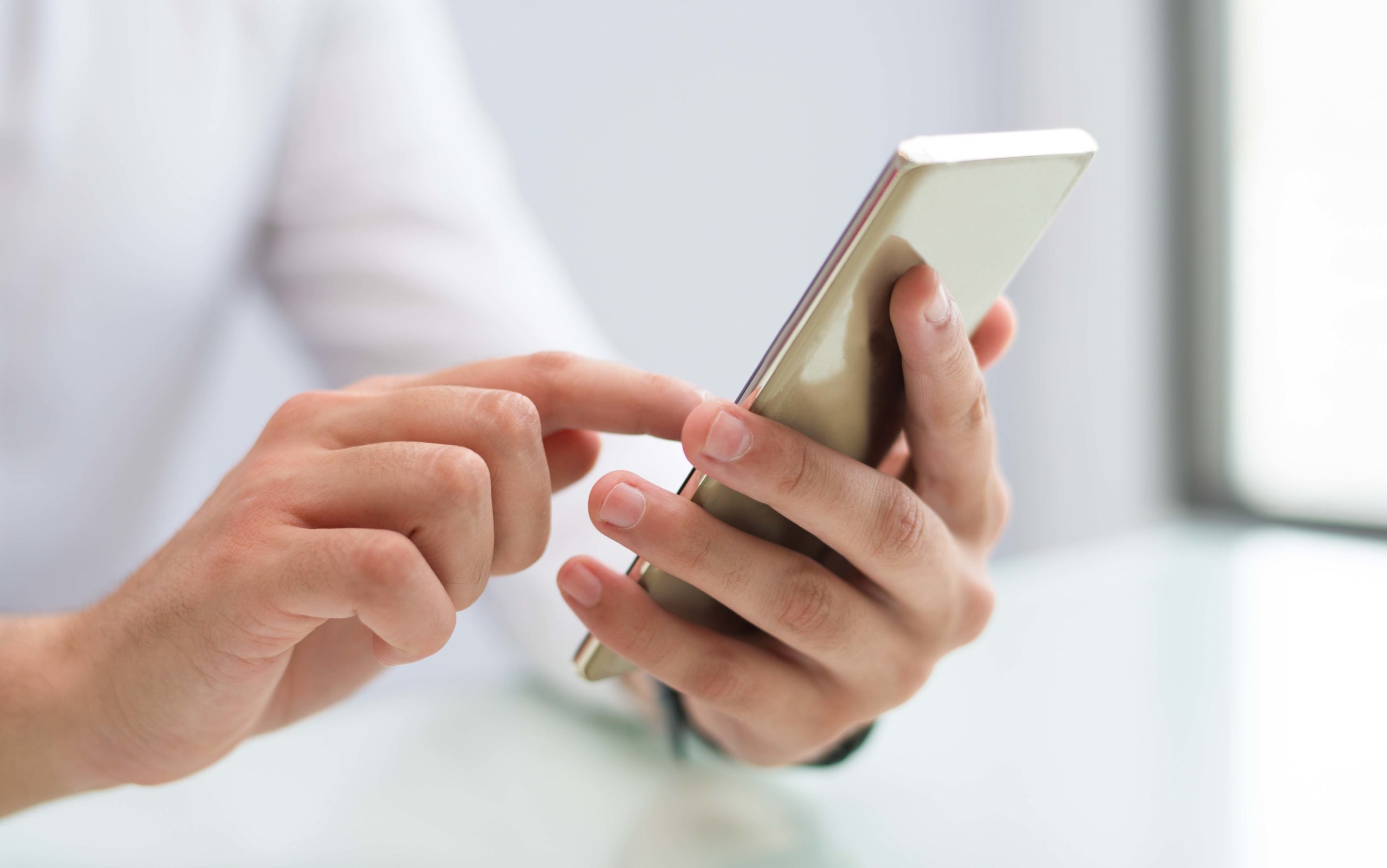 Close-up of male hands using smartphone