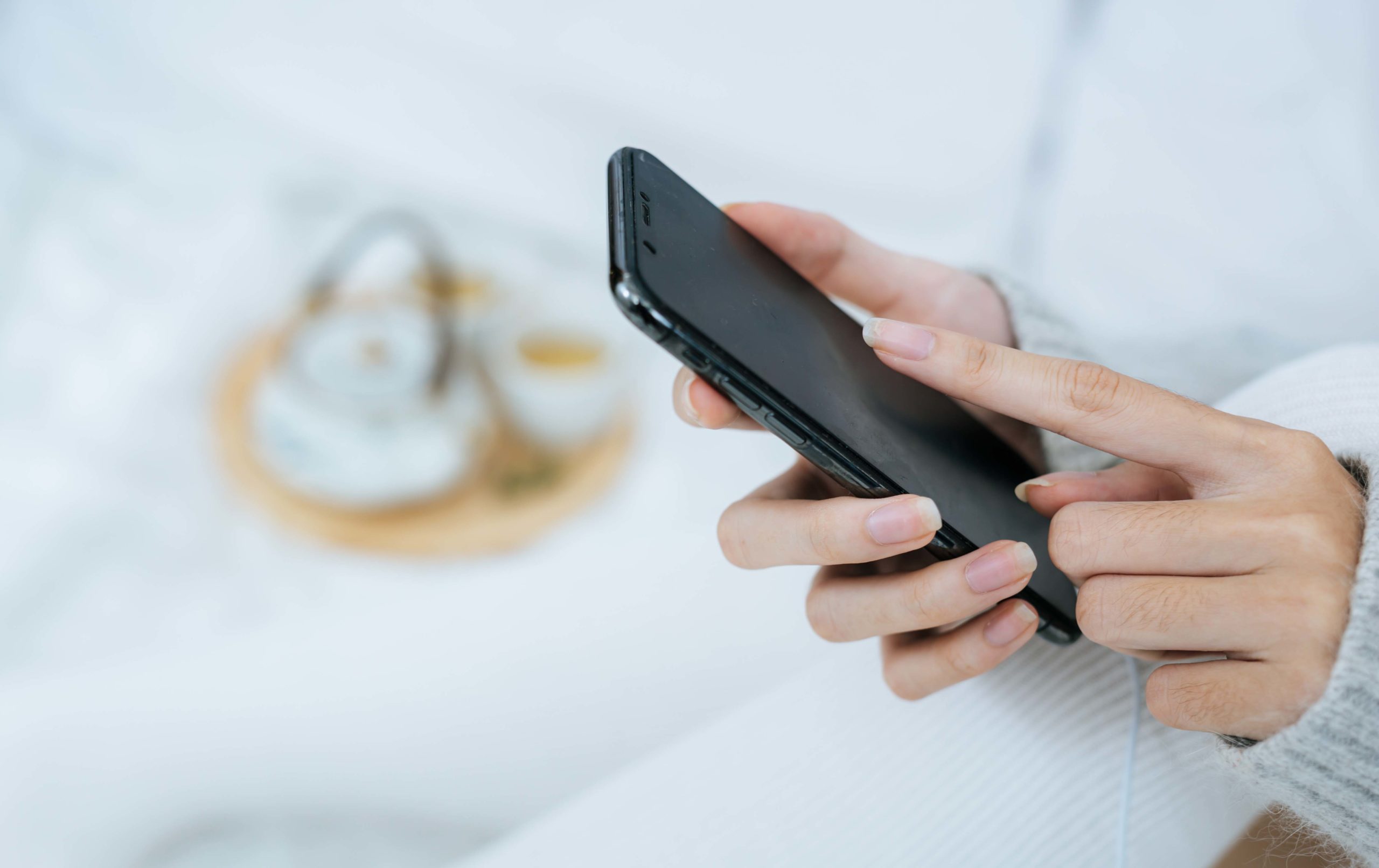 woman using smartphone on her bed in cold day