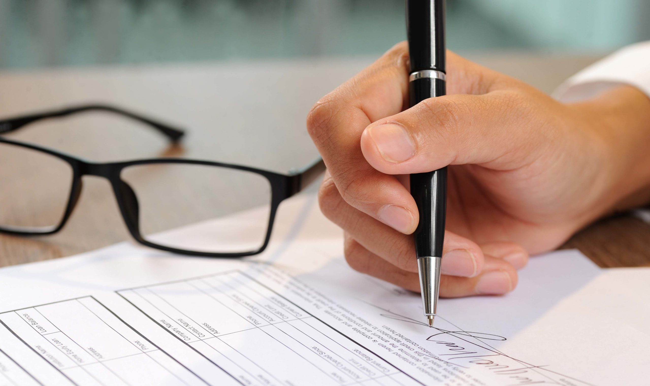Closeup of woman signing document