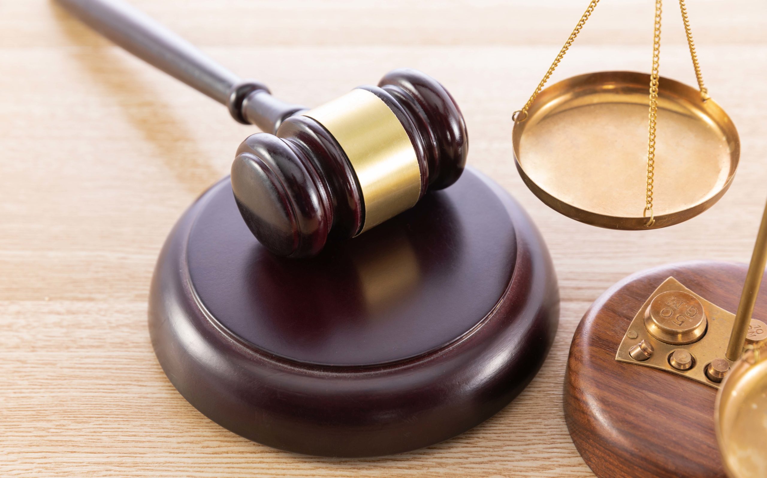 High angle shot of a gavel and a scale on a wooden surface