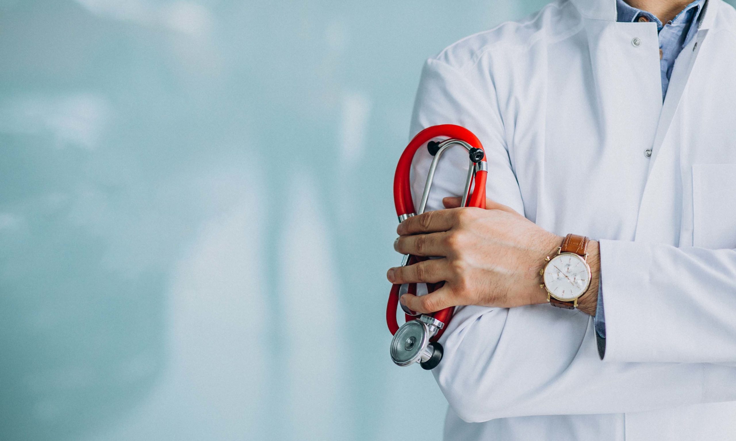 Young handsome physician in a medical robe with stethoscope