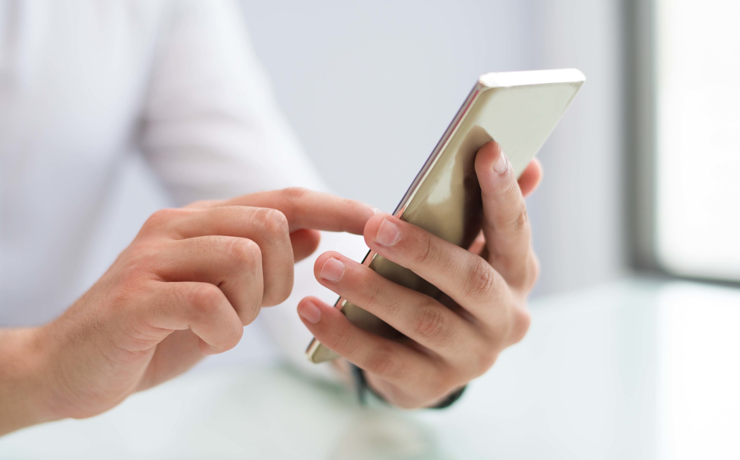 Close-up of male hands using smartphone