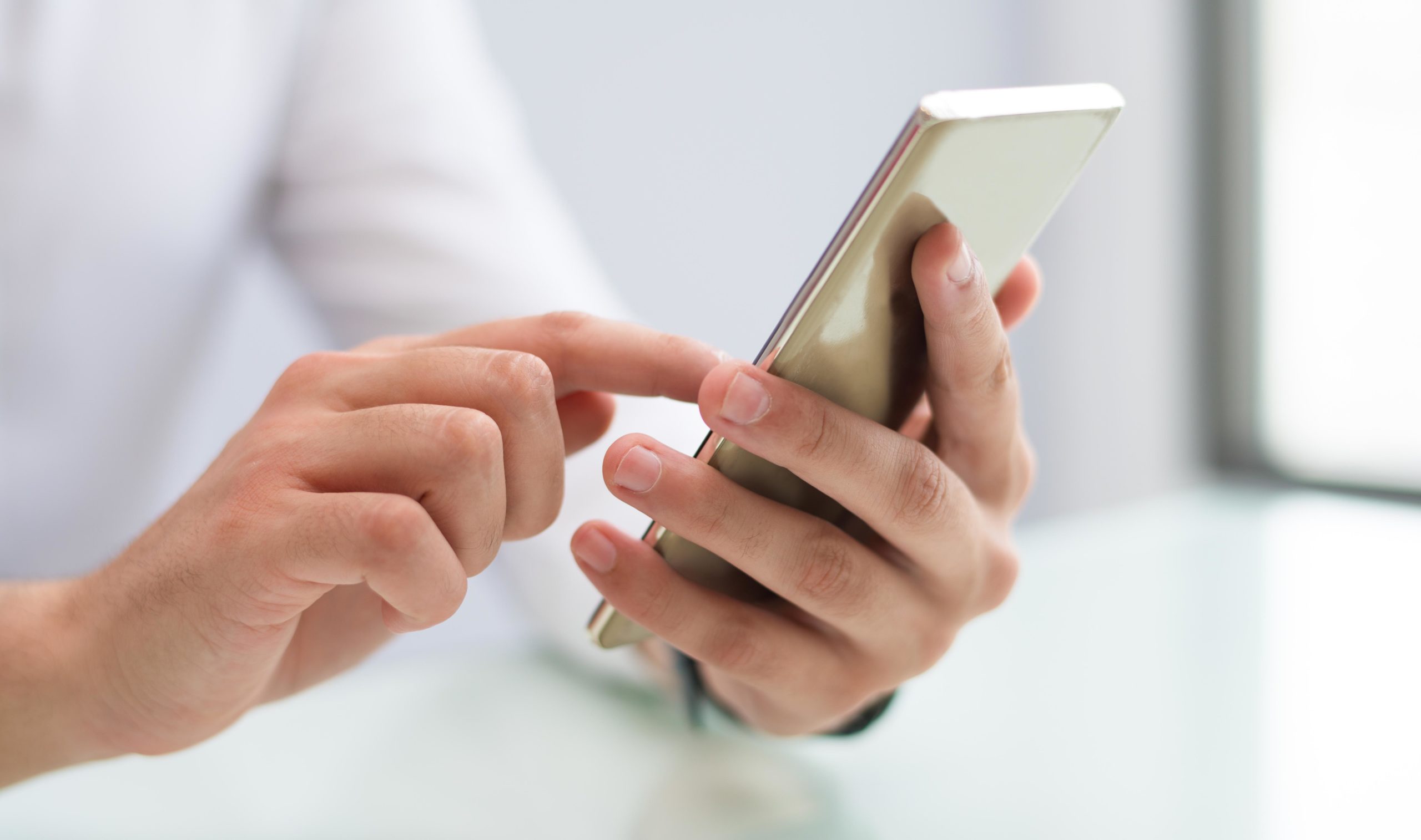 Close-up of male hands using smartphone